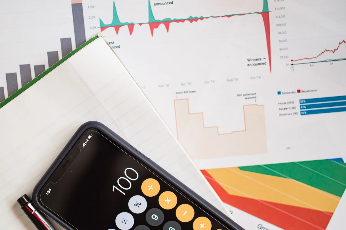 Informe financiero con gráficos y calculadora sobre una mesa